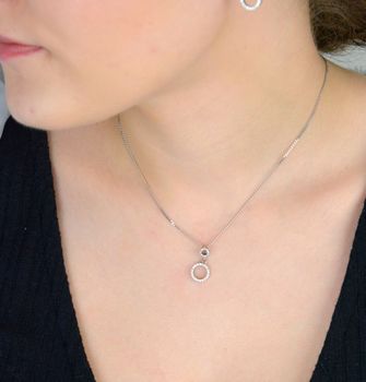 Stylowa srebrna zawieszka próby 925 z dwoma połączonymi kółeczkami, ozdobiona lśniącymi cyrkoniami. Symboliczna forma i elegancki blask – idealna na prezent lub do codziennych stylizacji. delikatny blask  W 2231  (3).JPG